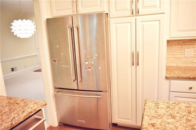 kitchen with tasteful backsplash, visible vents, light stone counters, cream cabinetry, and high end fridge