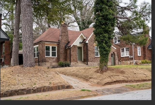 view of front of home with brick siding and a chimney