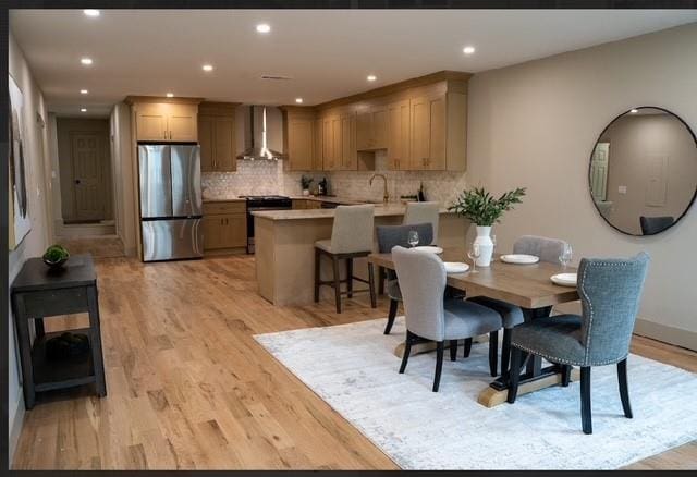 dining area with light wood-style flooring and recessed lighting