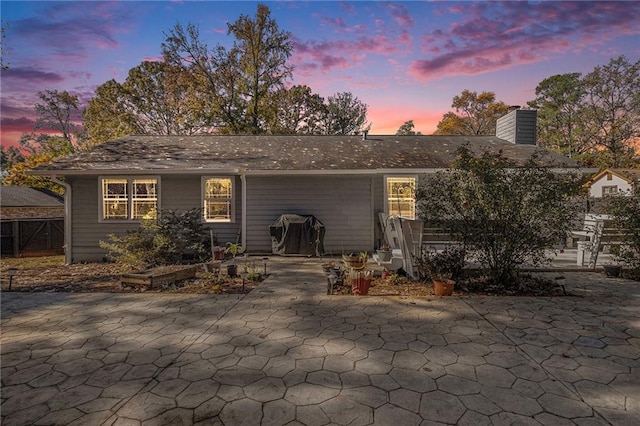 back house at dusk with a patio