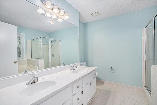 bathroom featuring tile patterned flooring, vanity, a textured ceiling, and plus walk in shower