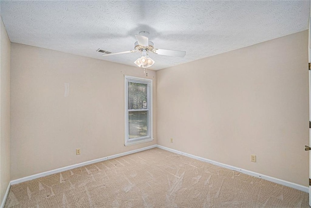 carpeted empty room featuring a textured ceiling