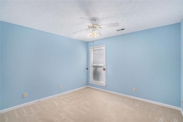 empty room with a textured ceiling, light colored carpet, and ceiling fan