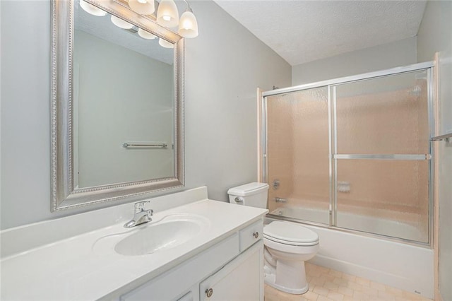 full bathroom featuring vanity, tile patterned floors, combined bath / shower with glass door, toilet, and a textured ceiling