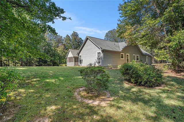 view of side of home with a yard