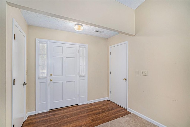 foyer entrance featuring dark hardwood / wood-style flooring and a textured ceiling