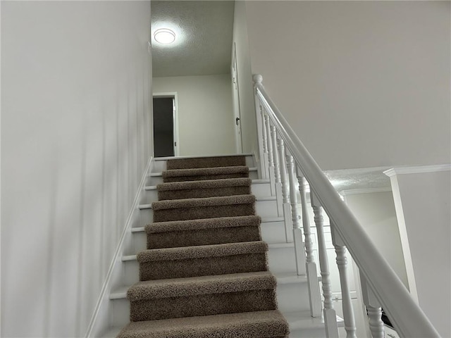 stairs with a textured ceiling