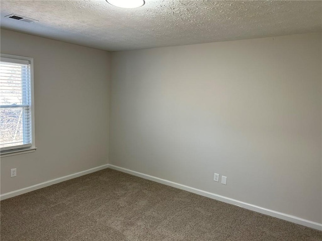 carpeted spare room featuring a textured ceiling