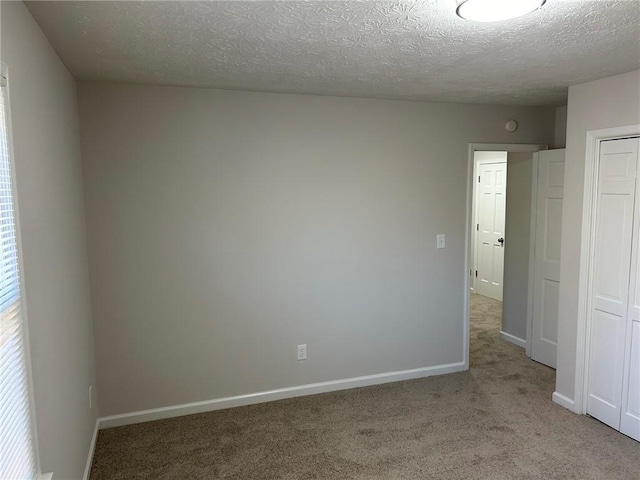 interior space featuring a closet, light carpet, and a textured ceiling