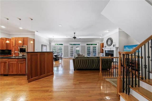1255 Beech Haven Rd NE, Atlanta, GA 30324 - living area with light wood-style floors, a ceiling fan, a warm lit fireplace, ornamental molding, and recessed lighting