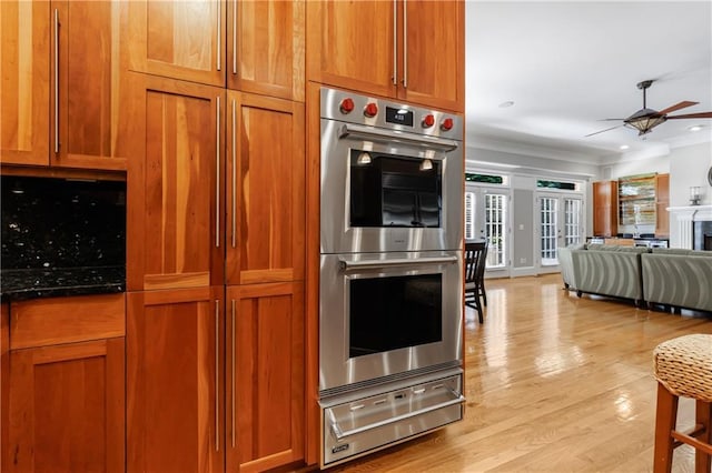 1255 Beech Haven Rd NE, Atlanta, GA 30324 - kitchen featuring a warming drawer, stainless steel double oven, a ceiling fan, light wood-style flooring, and brown cabinetry