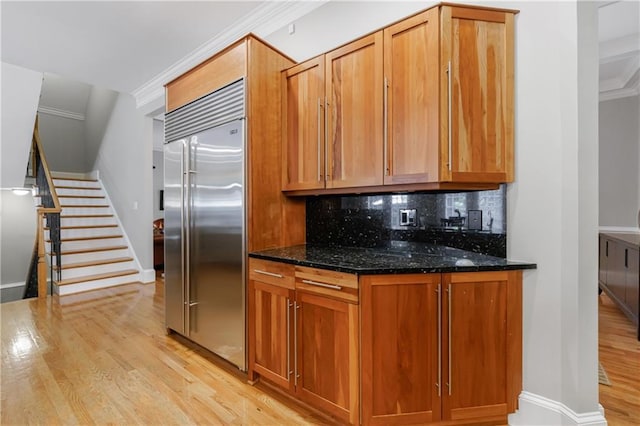 1255 Beech Haven Rd NE, Atlanta, GA 30324 - kitchen with stainless steel built in refrigerator, ornamental molding, light wood-type flooring, backsplash, and dark stone countertops