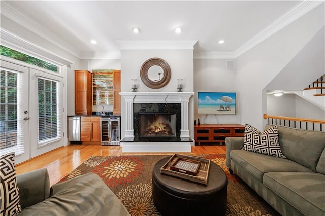 1255 Beech Haven Rd NE, Atlanta, GA 30324 - living room featuring beverage cooler, light wood-style flooring, crown molding, recessed lighting, and a high end fireplace