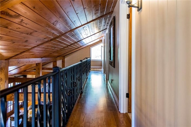 hallway with vaulted ceiling, wooden ceiling, and dark hardwood / wood-style flooring