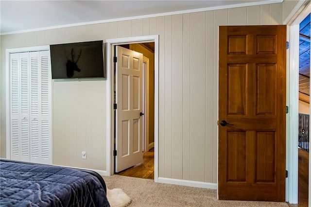 bedroom featuring light carpet, ornamental molding, and a closet