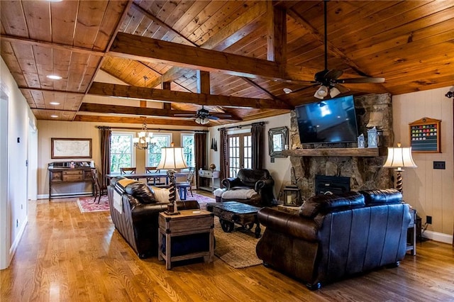 living room featuring lofted ceiling with beams, a stone fireplace, wooden ceiling, and light wood-type flooring