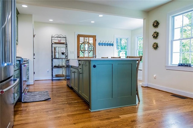 kitchen with stainless steel range, light hardwood / wood-style floors, and a kitchen island