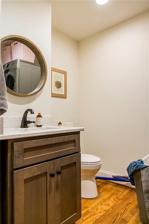 bathroom with vanity, toilet, and hardwood / wood-style floors