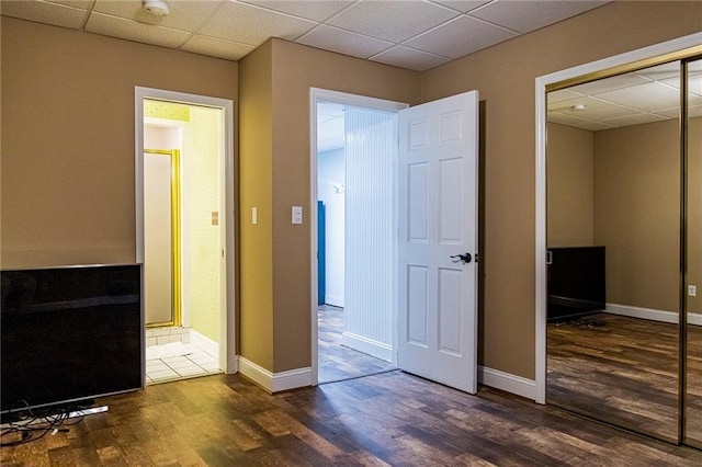 hall featuring dark hardwood / wood-style floors and a drop ceiling