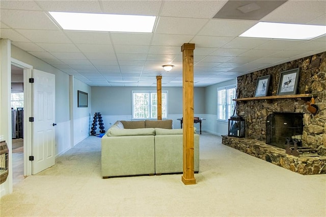 carpeted living room featuring a drop ceiling and a fireplace