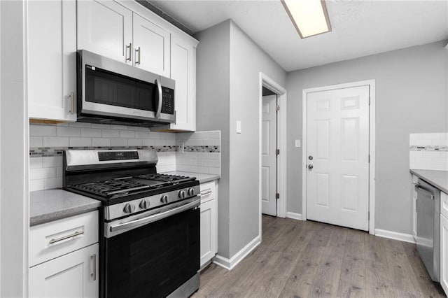 kitchen featuring backsplash, light wood-style flooring, white cabinetry, and stainless steel appliances