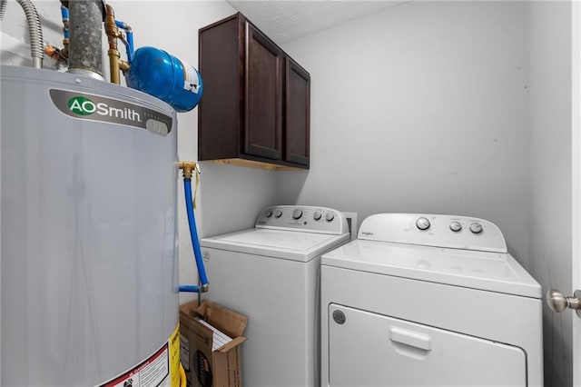 washroom featuring cabinet space, separate washer and dryer, water heater, and a textured ceiling