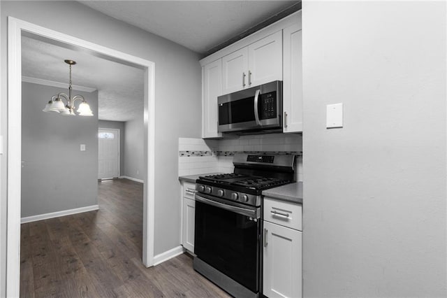 kitchen with baseboards, stainless steel appliances, dark wood-type flooring, white cabinets, and backsplash