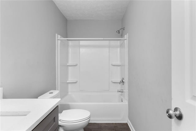 full bathroom featuring toilet, a textured ceiling, wood finished floors, tub / shower combination, and vanity