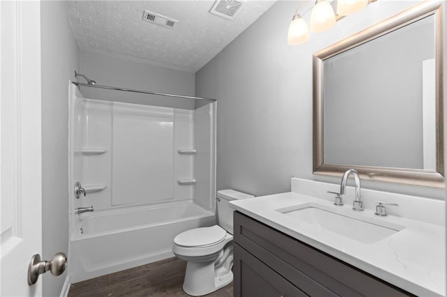 bathroom featuring visible vents, toilet, wood finished floors, and a textured ceiling