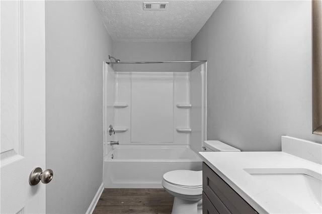 bathroom with vanity, wood finished floors, visible vents, a textured ceiling, and toilet