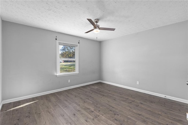 spare room featuring baseboards, wood finished floors, and a ceiling fan