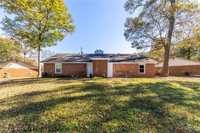 back of property featuring brick siding, a lawn, and cooling unit