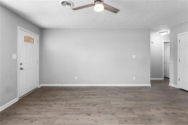 unfurnished room with visible vents, a textured ceiling, wood finished floors, and a ceiling fan