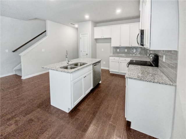 kitchen with sink, stainless steel appliances, an island with sink, and white cabinetry