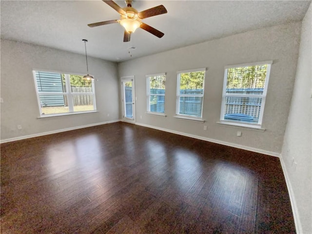 spare room with ceiling fan and dark wood-type flooring