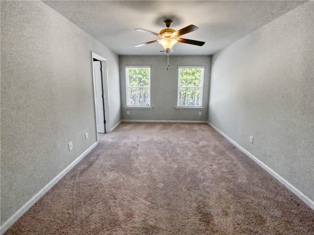 carpeted spare room with a textured ceiling and ceiling fan