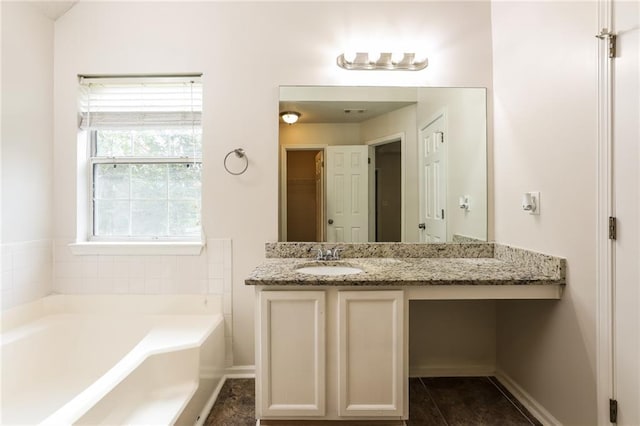 bathroom featuring vanity and a washtub