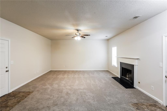 unfurnished living room with a textured ceiling, carpet flooring, and ceiling fan