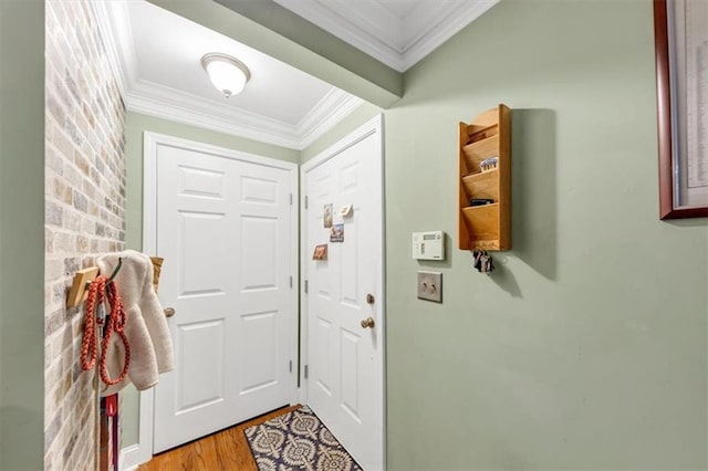 entryway with ornamental molding and light wood-type flooring