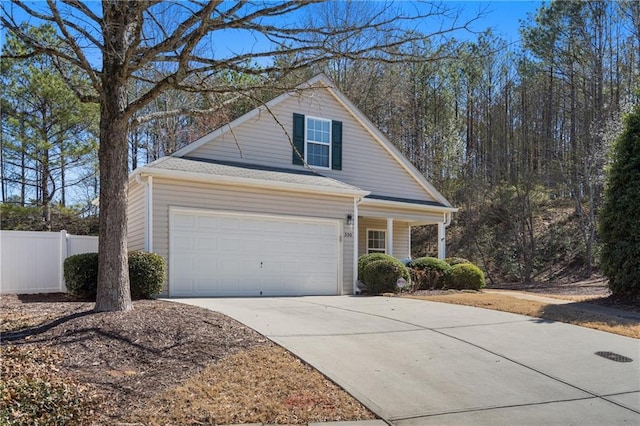 view of front facade featuring an attached garage, fence, and driveway