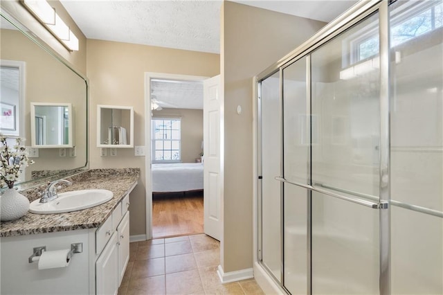 bathroom with a textured ceiling, a stall shower, vanity, and tile patterned flooring