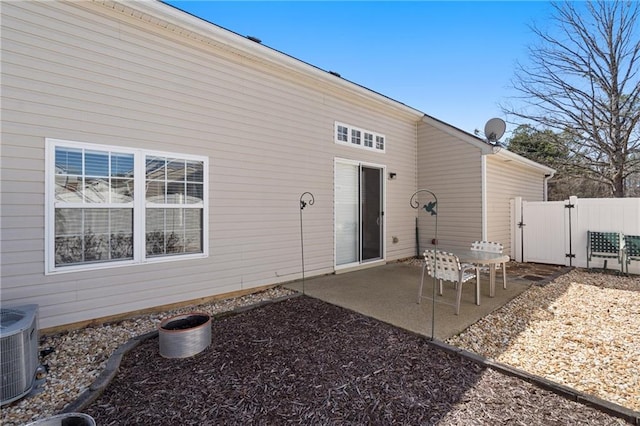 back of house with a patio area, central air condition unit, fence, and a gate