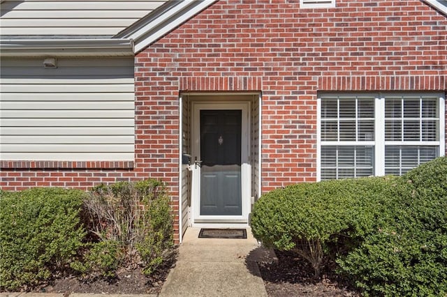 entrance to property featuring brick siding