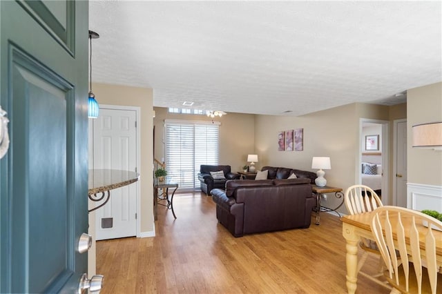 living area with a textured ceiling and light wood-type flooring