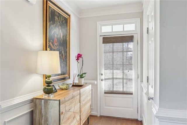 doorway featuring crown molding and light hardwood / wood-style floors