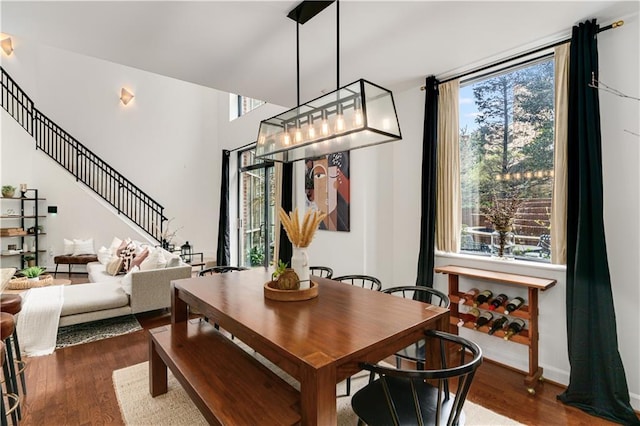 dining space featuring stairs, baseboards, and dark wood-style flooring