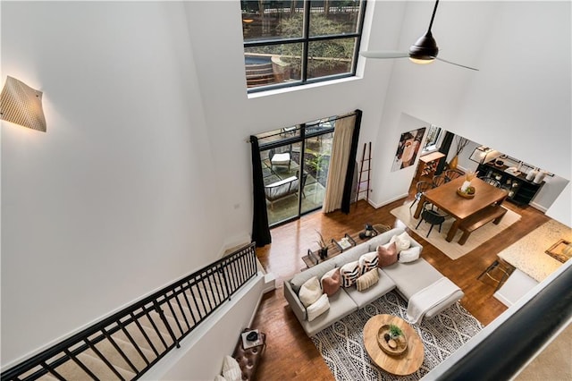 living area featuring a high ceiling, wood finished floors, and a ceiling fan