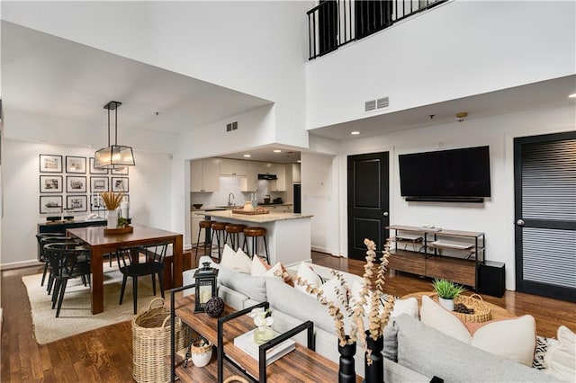 living area featuring dark wood-style floors, visible vents, and baseboards