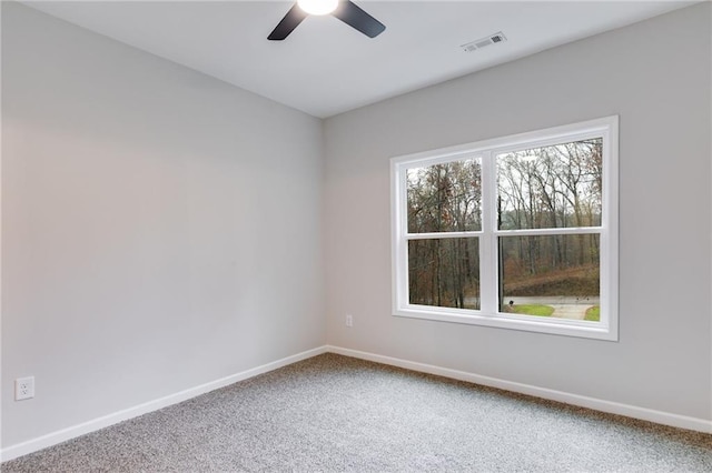 carpeted empty room with visible vents, ceiling fan, and baseboards