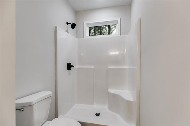 bathroom featuring a shower and toilet